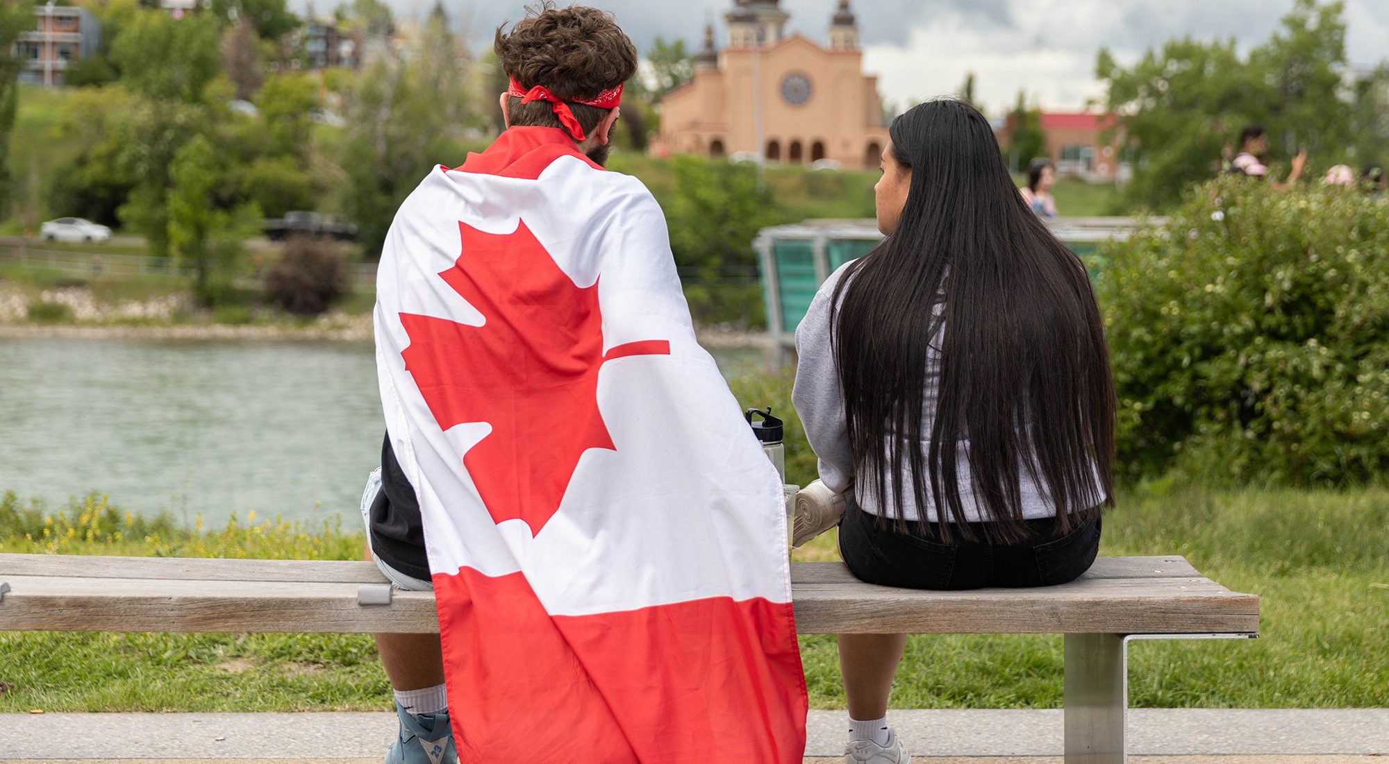 two people on a park bench celebrating Canada Day