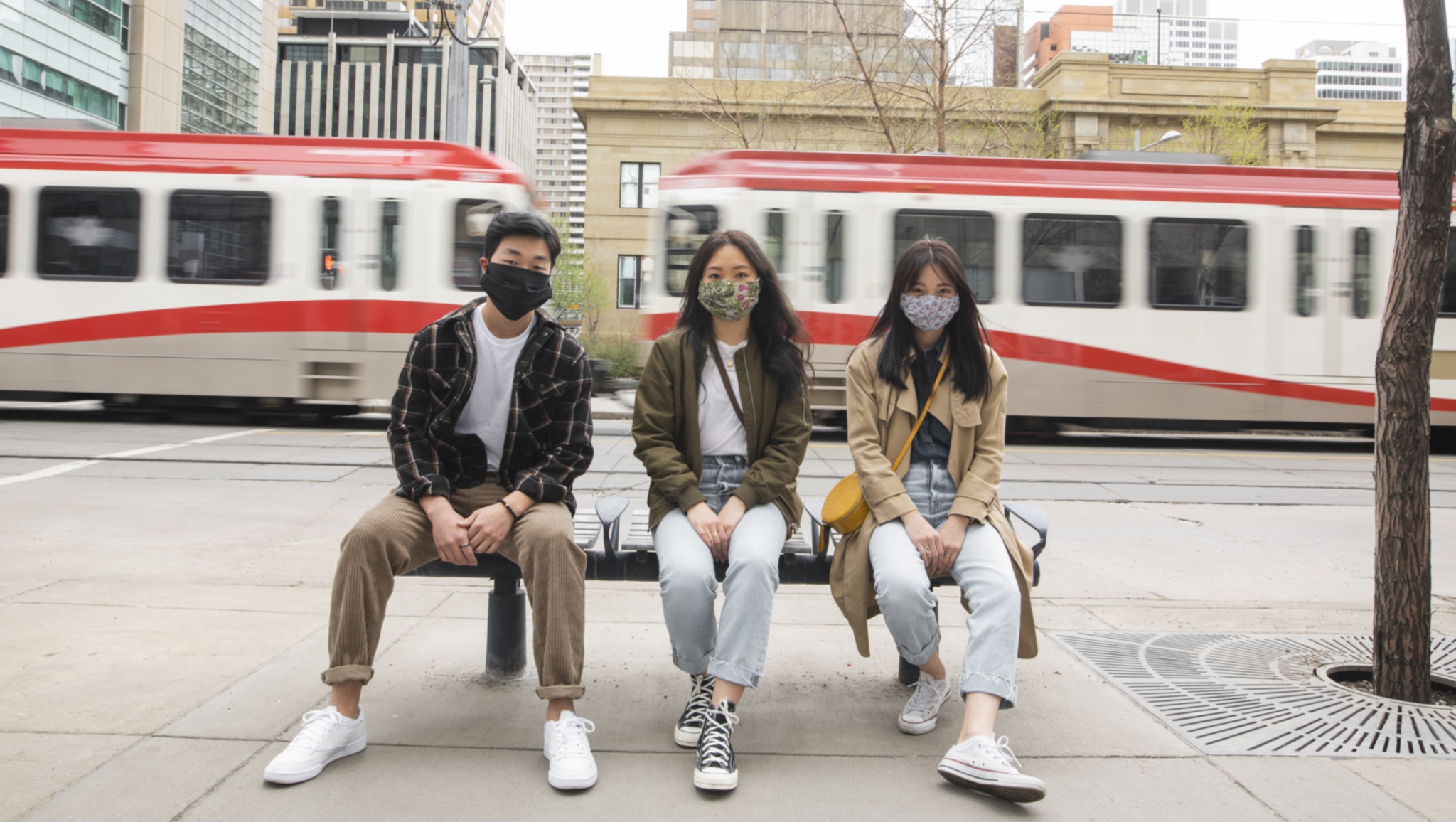 people with masks on a bench