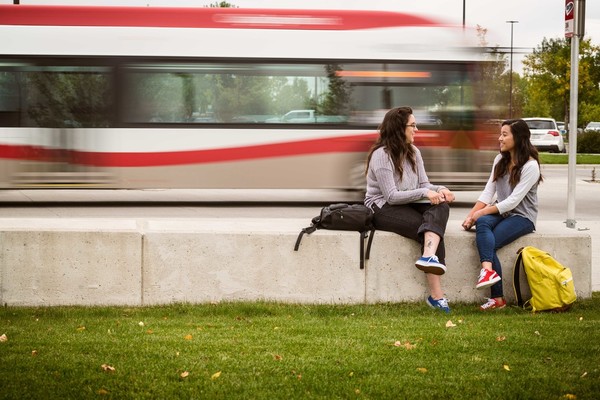 People sitting while a bus drives by